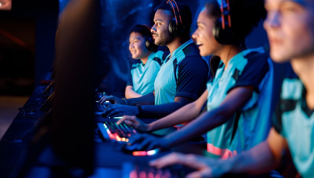 Team of professional gamers playing on pc in gaming club