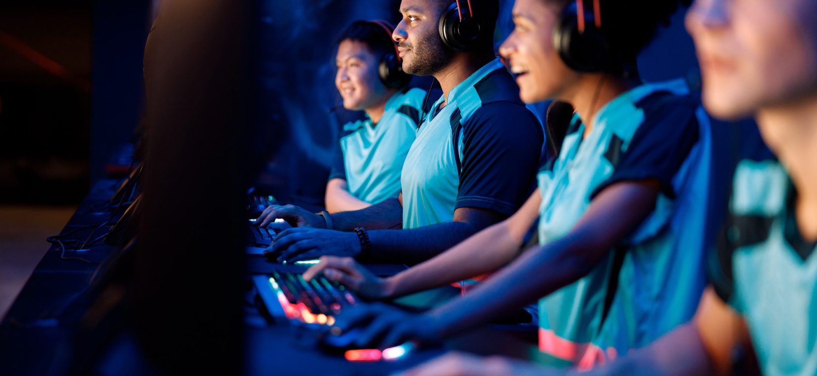 Team of professional gamers playing on pc in gaming club