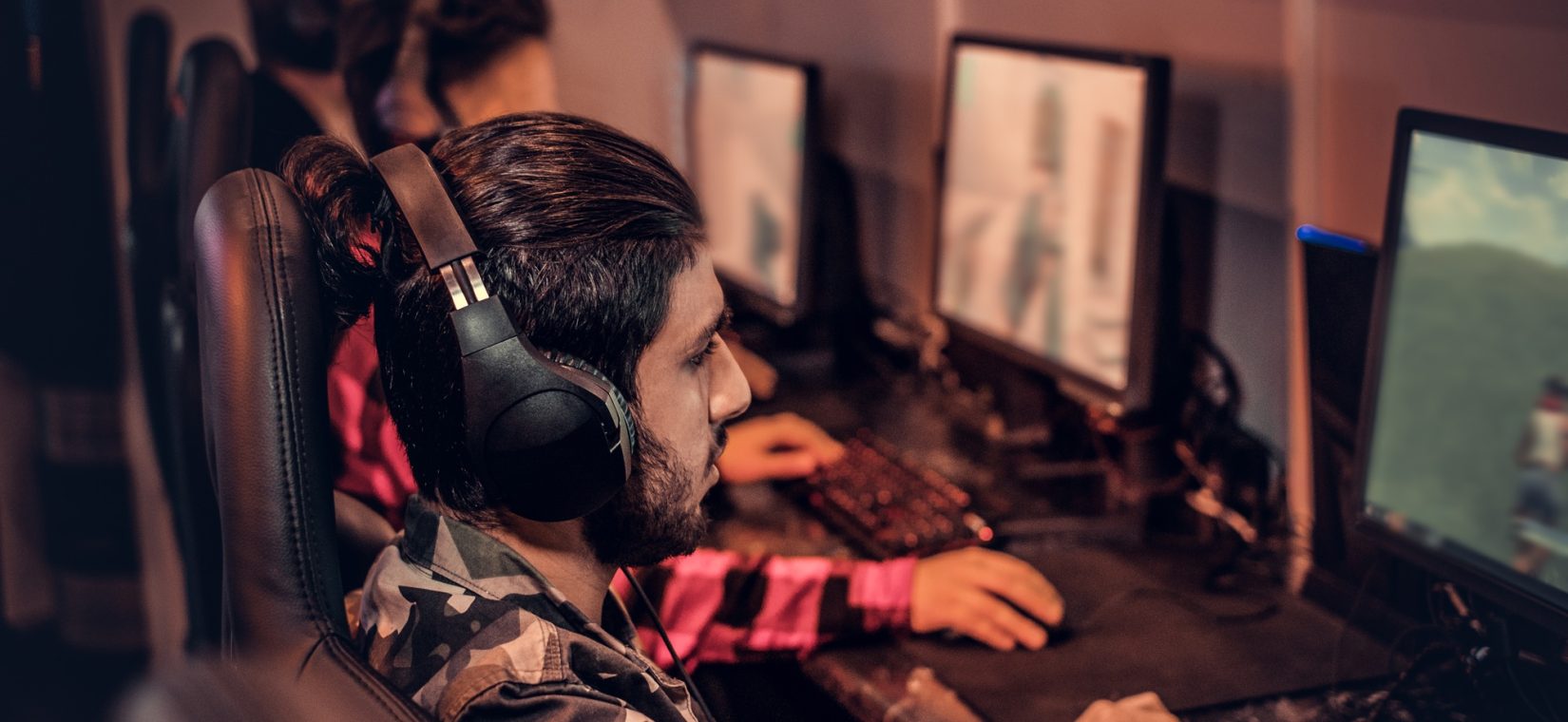 Team of teenage gamers plays in a multiplayer video game on pc in a gaming club.